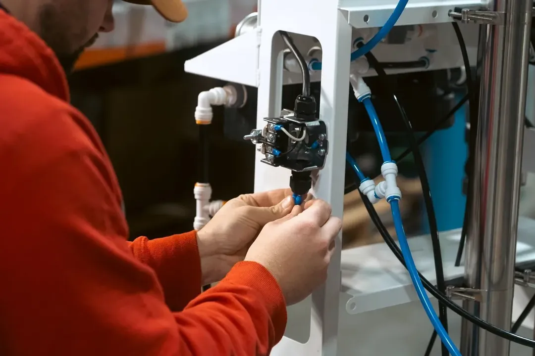 A Crystal Quest technician fitting the tubing on a water treatment system during assembly